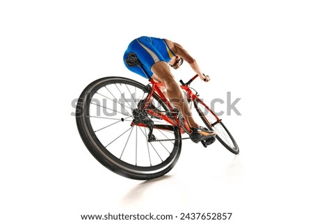 Bottom view dynamic image of man, athlete, cyclist in motion riding on bike isolated on white studio background. Concept of sport, active and healthy lifestyle, speed, endurance, hobby