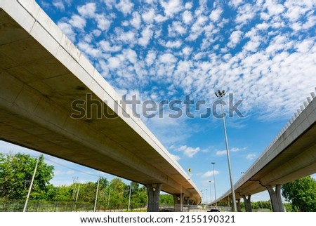 Bottom view of elevated concrete highway. Overpass concrete road. Strong structure of cement bridge. Concrete bridge engineering construction. Bridge architecture. Infrastructure budget policy concept