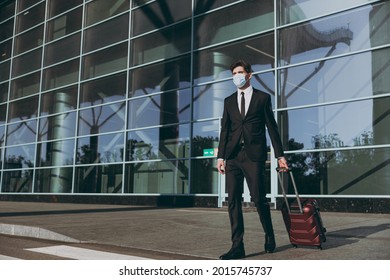 Bottom View Full Body Young Traveler Businessman Man 20s Wear Black Dinner Suit Facial Mask Walking Go Outside At International Airport Terminal With Suitcase Valise Air Flight Business Trip Concept