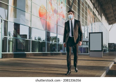 Bottom View Full Body Young Traveler Businessman Man In Black Dinner Suit Sterile Mask Standing Outside At International Airport Terminal Look Aside. People Air Flight Business Trip Lifestyle Concept