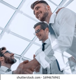 bottom view. handshake employees over the Desk