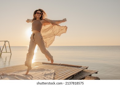 Bottom View Of Happy Caucasian Young Girl Admiring Sunrise Or Sunset On Tropical Beach. Brown-haired Woman In Sunglasses Is Having Fun. Nice Vacation By The Sea.