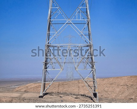 Bottom view of a high-voltage tower in alignment with other towers
