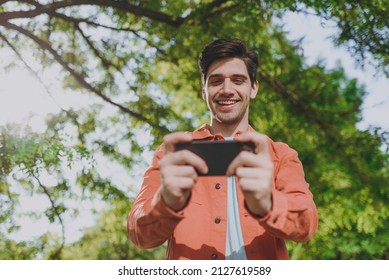 Bottom View Man In Orange Jacket Walk Play Racing App On Mobile Cell Phone Gadget Smartphone Rest Relax In Spring Green City Park Go Down Alley Sunshine Lawn Outdoor On Nature Urban Leisure Concept