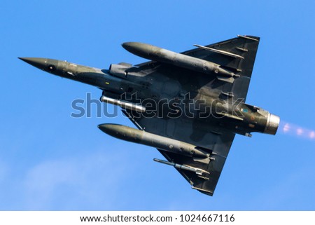 bottom view of a military fighter jet aircraft in flight.