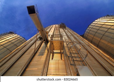 Bottom view of a modern metal silo at sunset