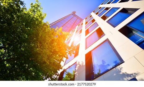 Bottom view of modern skyscraper in business district against blue sky. Looking up at business buildings in downtown. Rising sun on the horizon. - Shutterstock ID 2177520279