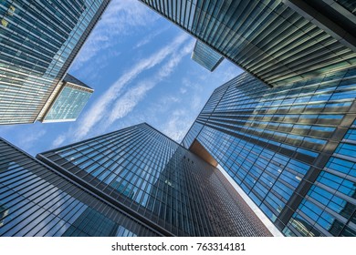 Bottom view of modern skyscrapers in business district against blue sky - Shutterstock ID 763314181