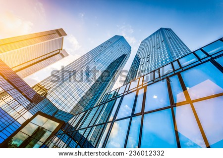 Bottom view of modern skyscrapers in business district in evening light at sunset with lens flare filter effect