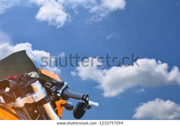Bottom view of the motorcycle front and\
beautiful blue sky and white\
clouds\
