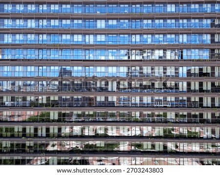 Bottom view of office building window close up, reflection and perspective. Modern architecture with sun ray. Glass facade on a bright sunny day.