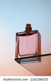 Bottom view of one spray bottle of perfume stands on a glass table