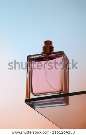 Bottom view of one spray bottle of perfume stands on a glass table