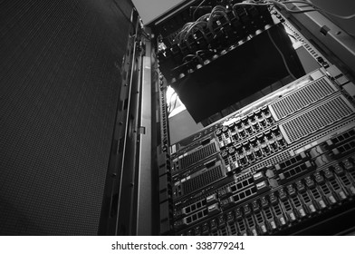 Bottom view of rack server against neon light in datacenter with dept of field in black & white tone