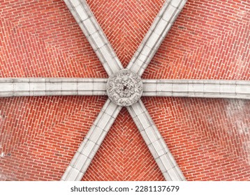 Bottom view of a red brick ceiling with a stone arch