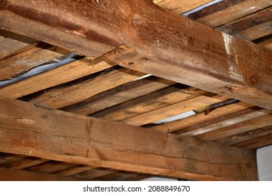 Bottom view of the roof of a house consisting of beams and planks.