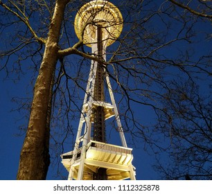 Bottom view of Space Needle through through tree branches 