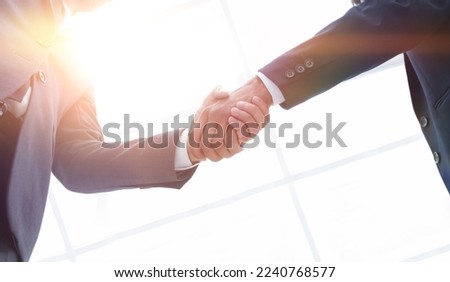 bottom view of two men shaking hands while standing