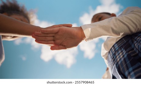 Bottom view two schoolgirls friends little girls school students children multiethnic female kids daughters pupils primary education class unity teamwork putting hands stack together connect outdoors - Powered by Shutterstock