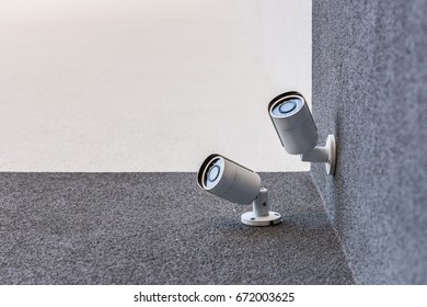 bottom view of two security cameras on office building, security system concept