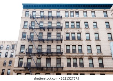 Bottom view of a typical tall multi story New York City apartment building, no people. Looking up at a New York City style apartment building.