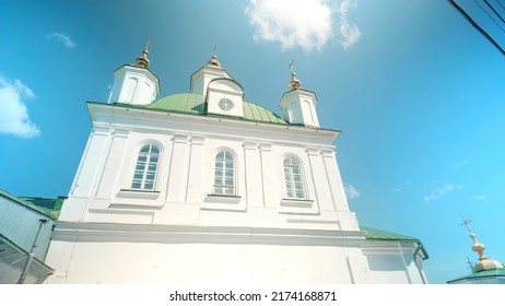 Bottom view of a white church building. Action. Concept of architecture and religion, renovated facade of a building on a cloudy sky background.