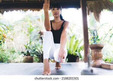 Bottom View Of Young Asian Girl Practicing Yoga On Wooden Terrace. Concept Of Healthy Lifestyle. Focused Athletic Woman Wearing Sportswear And Barefoot On Fitness Mat. Bali Island. Sunny Day