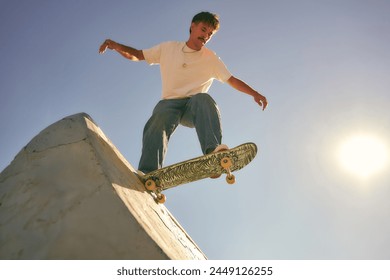 Bottom view of young man doing tricks on his skateboard at the skate park. Active sport concept - Powered by Shutterstock