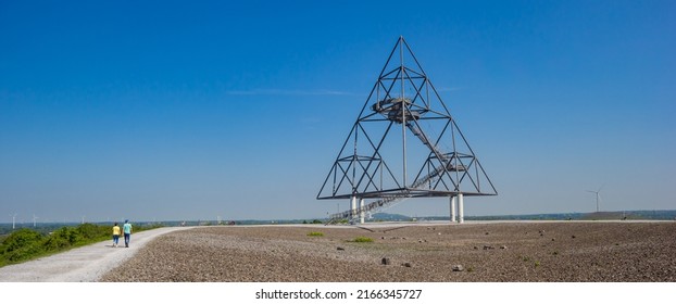 BOTTROP, GERMANY - MAY 09, 2022: Panorama of a young couple walking to the tetrahedron in Bottrop, Germany