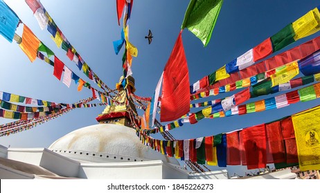 The Bouddhanath Temple in Kathmandu, Nepal. The temple has many colourful prayer flags with 'om mani padme hum' mantra written on them attached to it's golden rooftop. Spirituality and meditation.