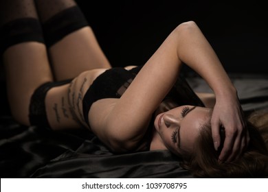 Boudoir Photography Of A Beautiful Young Woman Over Dark Background