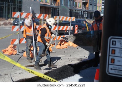 Boulder, CO USA - April 8, 2022: Construction Worker Crew Pour Black Asphalt To Fill A Hole In The Road. Road Maintenance. Heavy Machinery.