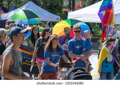 Boulder, Colorado / United States Of America - September 8th, 2019 : A Family Wearing Matching Tshirts, Carrying A Small Child, And Pushing A Stroller, Walk Together During Boulder Pridefest.