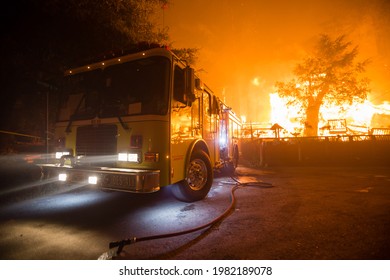 BOULDER CREEK, CALIFORNIA - AUGUST 21, 2020: A CAL-OES Fire Engine Is Set Up Near A Fully Engulfed Home During The CZU Lightning Complex Wildfire.