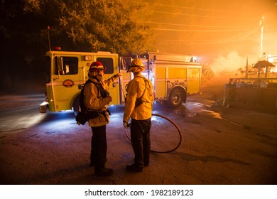 BOULDER CREEK, CALIFORNIA - AUGUST 21, 2020: Firefighters Converse Near A Fully Engulfed Home During The CZU Lightning Complex Wildfire.