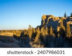 Boulder fields of Vedauwoo in Wyoming. Sherman Granite boulders in Medicine Bow -Routt National Park. Vedauwoo boulders in afternoon sun with dark blue sky and scrub trees.