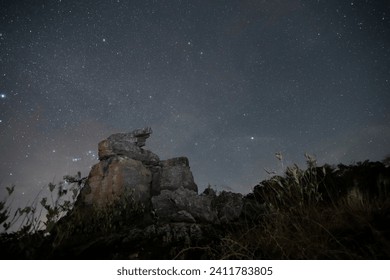 Boulder stack foreground with starry at night.
