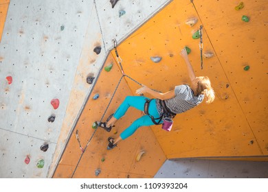 bouldering, girl climbing up the wall - Shutterstock ID 1109393204