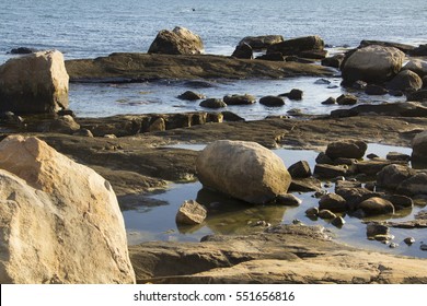 Boulders on the beach with tide pools along the southern coastline of Connecticut on Long Island Sound of the Atlantic Ocean.