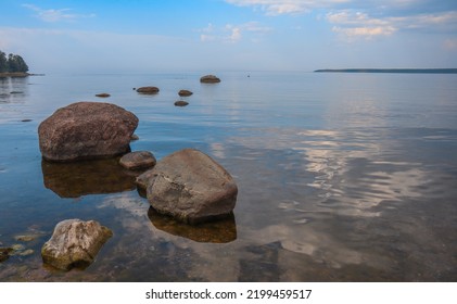 Boulders In The Sea And Clouds Reflecting Back On The Still Water By The Rocky Baltic Coastal Shoreline In Käsmu, Estonia.