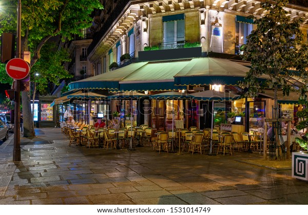 Boulevard San-German with tables of cafe in Paris\
at night, France. Architecture and landmarks of Paris. Postcard of\
Paris