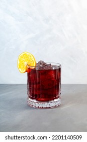 Boulevardier cocktail with ice cubes and orange slice. Classic alcoholic drink composed of whiskey, sweet vermouth, and Campari. Selective focus, vertical orientation. - Shutterstock ID 2201140509