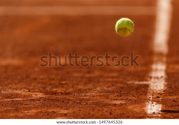 Bouncing tennis ball on clay\
court
