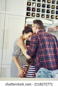 Bound together by love. Shot of a husband lovingly kissing his wife in the kitchen with his family.
