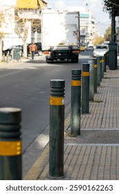 Boundary posts between the sidewalk and the highway. Parking restrictions