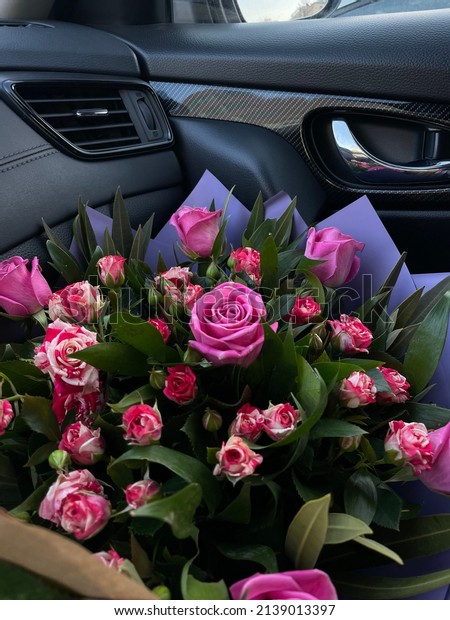 A bouquet of\
beautiful red roses in the car\
