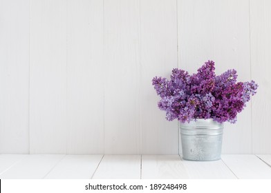 Bouquet of beautiful spring flowers of lilac in a vase on a white vintage wooden board, home decor in a rustic style - Powered by Shutterstock