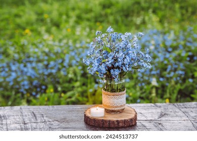 Bouquet of blue blossom wild flowers Myosotis also known as Forget me not or scorpion grasses in decorated mason jar. Beautiful vintage floral still life. - Powered by Shutterstock