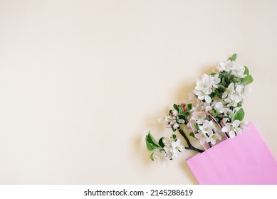 A Bouquet Of Branches Of A Blossoming Apple Tree In A Pink Shopping Bag On A Beige Background. Top View, Flat Lay, Copy Space. Spring Discount Concept. Seasonal Sale. Time For Shopping.