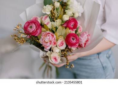 Bouquet for the bride in female hands. Flowers for the wedding. Leukadendron, ranunculus, genista. Tulips, roses, carnation shabot